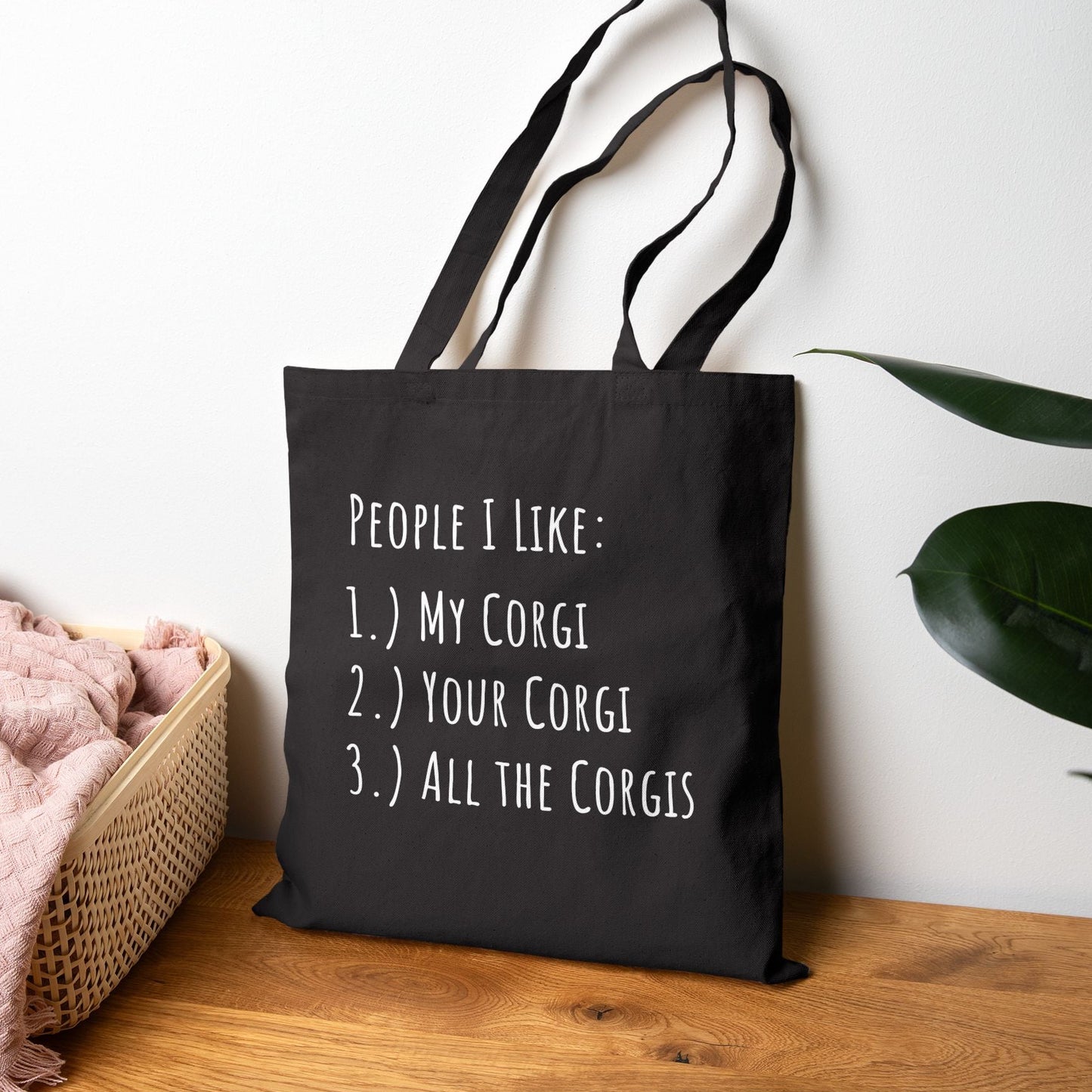 Black tote bag with a blue car graphic and text on a wooden surface.