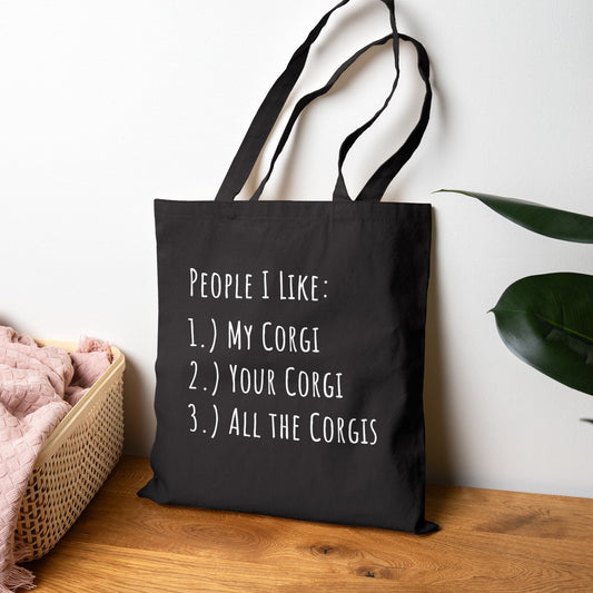 Black tote bag with a blue car graphic and text on a wooden surface.